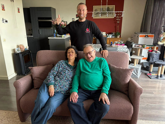 Blije klanten op bank in woonkamer na stoffering, meubelstoffeerderij Amsterdam