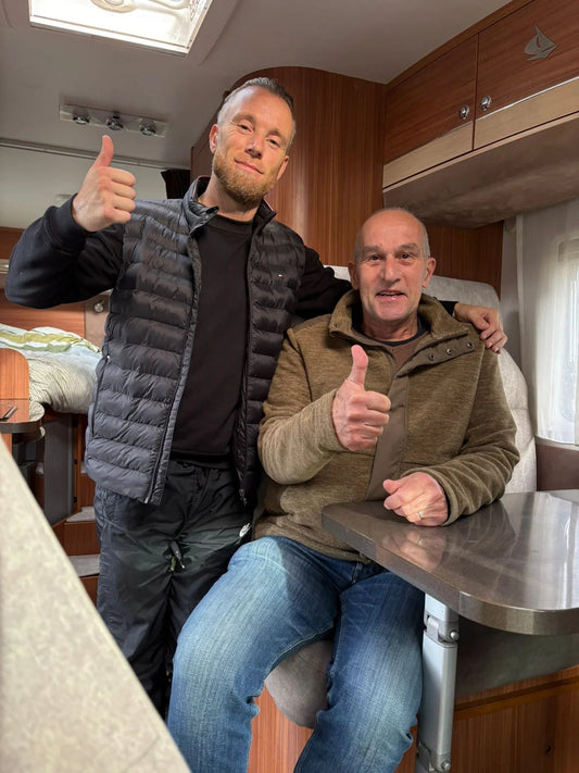 Twee mannen geven duim omhoog in camper, meubelstoffeerderij Amsterdam interieur op maat.